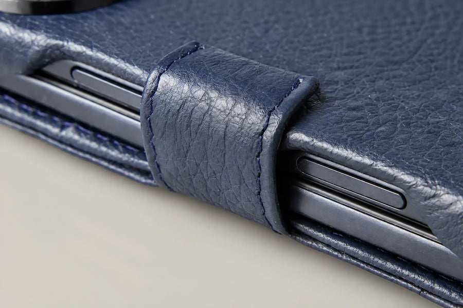 Macro of the folded leather edge of a Vaja Duo case with the side buttons exposed